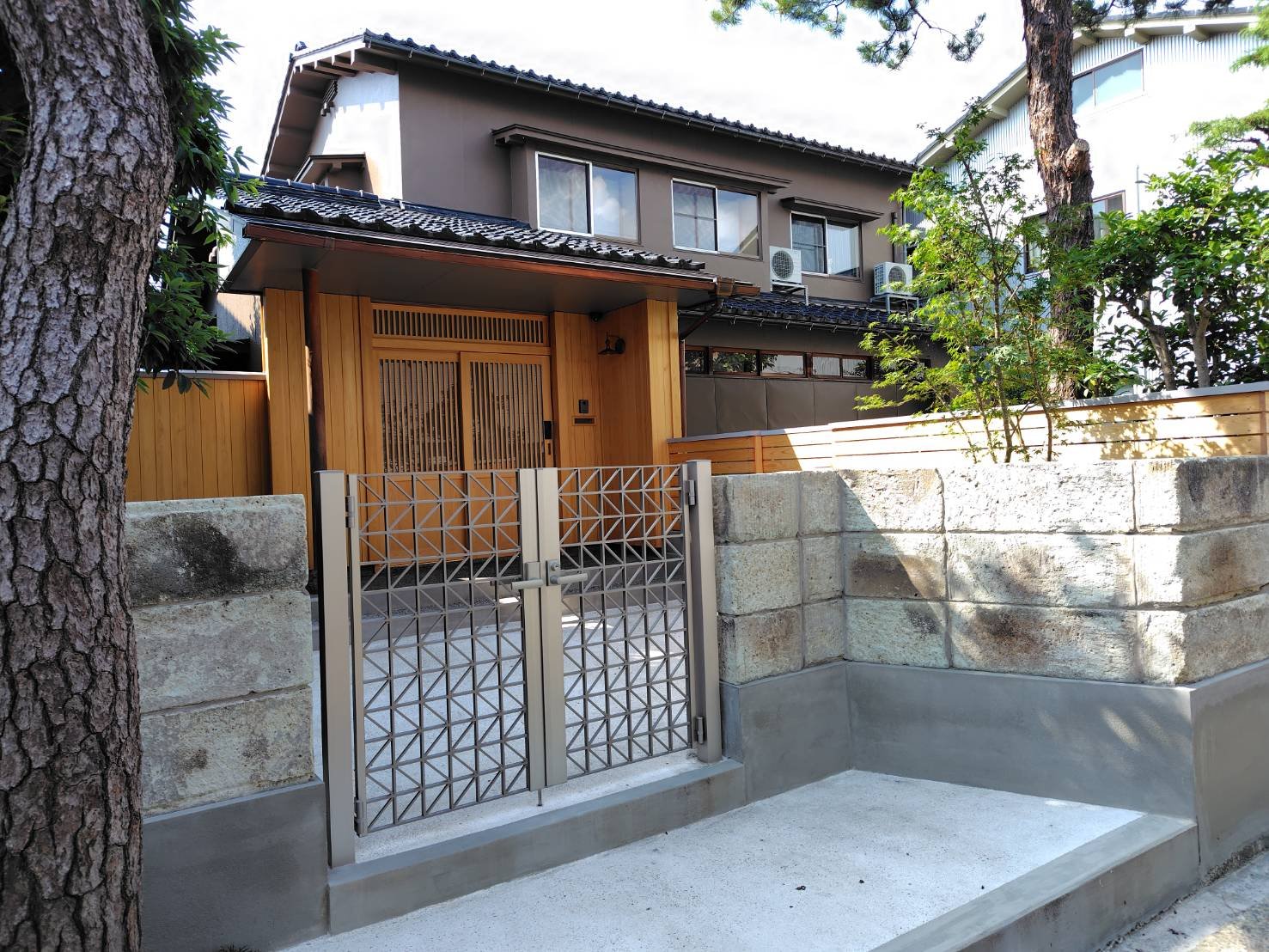 庭木と石垣を生かした家全体リフォーム施工後の外観